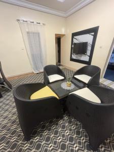a living room with two chairs and a table and a mirror at Residence FATIMA in Thiès