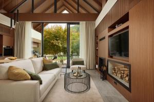 Una sala de estar con un sofá blanco y una chimenea. en Terra Homes, en Kolašin