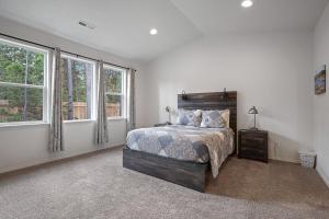 a bedroom with a large bed and two windows at Four Seasons Retreat in Sunriver