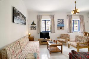 クアルテイラにあるApartamento T1 Edisolのソファとテレビのあるリビングルーム