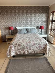 a bedroom with a bed and two tables with lamps at SEE n BERG RUSPLEK in Tergniet