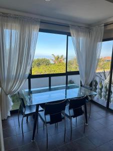 a dining room with a table and chairs and a large window at SEE n BERG RUSPLEK in Tergniet