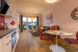 Una cocina y una sala de estar con mesa y sillas. en Ferienwohnung Büsumperle weiß, en Büsum