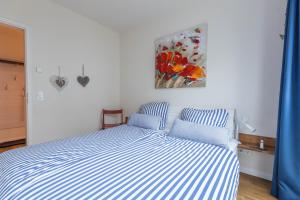 Una cama en un dormitorio con un cuadro en la pared. en Ferienwohnung Büsumperle weiß, en Büsum