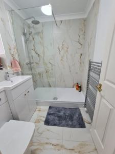 a white bathroom with a tub and a sink at Lomond Gardens Place in Addington