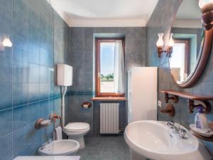 un bagno con lavandino, WC e specchio di Appartamento Bella Cora a Lazise Altre 18 foto