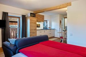 Studio Santnerblick Gfliererhof في Vols am Schlern: غرفة نوم مع أريكة زرقاء ومطبخ +16 صورة