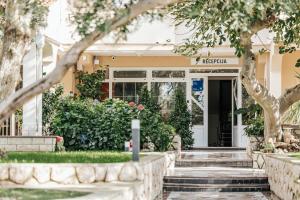 eine Haustür eines gelben Hauses mit einem Baum in der Unterkunft Resort Trcol in Novalja