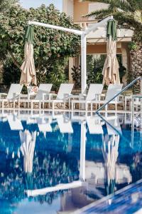 ein Pool mit Stühlen und Sonnenschirmen neben einem Resort in der Unterkunft Resort Trcol in Novalja