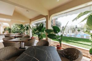 a patio with tables and chairs and plants at Resort Trcol in Novalja