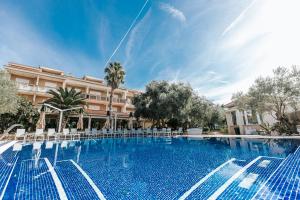 诺瓦利娅Resort Trcol的建筑物前有一个大型游泳池。