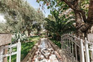 a white fence in front of a yard with trees at Resort Trcol in Novalja +167 photos