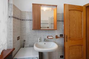 un baño con lavabo y espejo en Residence Malibu Appartamento 1, en Falcade 17 fotos más