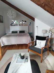 a bedroom with a bed and a chair and a table at La Suite 27 bis, maison indépendante avec terrasse, proche gare et centre in Guingamp