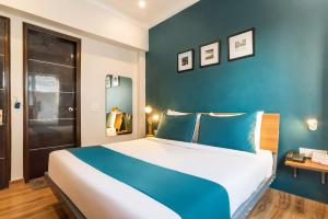 um quarto com uma cama grande e paredes azuis em Hotel King Near Delhi Airport em Nova Deli