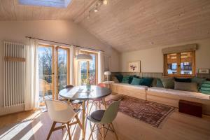 un salon avec un canapé, une table et des chaises dans l'établissement Ferienwohnung Bei der Töpferei, à Pittenhart