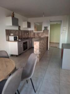 a kitchen and dining room with a table and chairs at Appartement confortable à Saint-Joseph avec piscine in Long-Bois