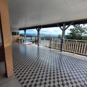 a room with a balcony with a view of the water at Appartement confortable à Saint-Joseph avec piscine in Long-Bois
