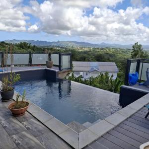 a swimming pool on the roof of a house at Appartement confortable à Saint-Joseph avec piscine in Long-Bois