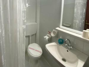 a white bathroom with a toilet and a sink at Saint George Hotel in Rodakino +54 photos