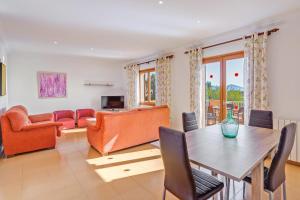 a living room with orange furniture and a table at Villa Luis Vives in Port de Pollensa