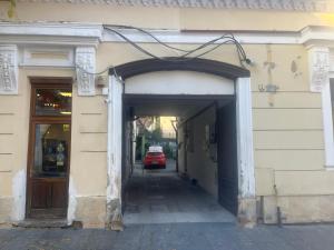 an entrance to a building with a car in a tunnel at La Palma Cave Historic Stone Apartment in Old Town Cluj in Cluj-Napoca