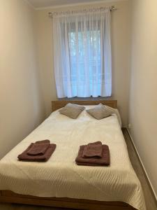 two towels on a bed in a bedroom with a window at Apartamenty Studzienna in Inowrocław