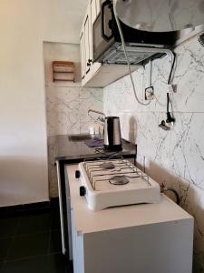 a white stove top oven sitting on a counter in a kitchen at Zurita Apart in San Fernando del Valle de Catamarca