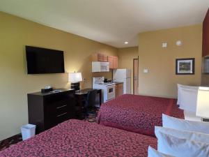 a hotel room with two beds and a desk and a kitchen at SureStay Studio By Best Western El Dorado in El Dorado +15 photos