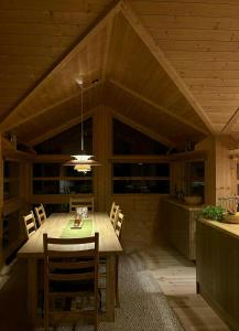 a kitchen and dining room with a table and chairs at Ål Cabin With Views Of Marshland And Mountains in Haglebu +29 photos
