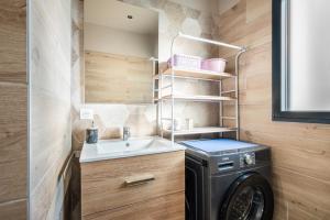 a laundry room with a sink and a washing machine at T3 Cros De Cagnes Bord De plage in Cagnes-sur-Mer