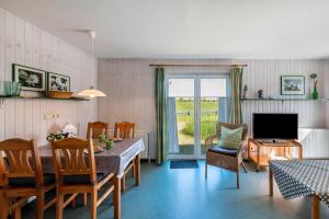a living room with a table and chairs and a television at Möve Aba Bungalow 61 in Rerik