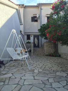 奧米沙利的住宿－Apartment Melina，石质庭院上的白色椅子