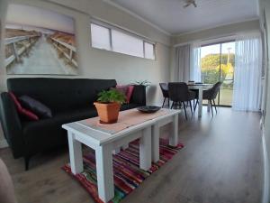a living room with a couch and a table at Kaaimans Crest Ocean-View Studio in Great Brak River