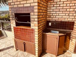 a brick pizza oven in a brick wall at Experiência única em Bombinhas frente ao Mar. in Bombinhas