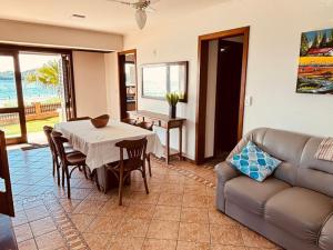 a living room with a table and a couch at Experiência única em Bombinhas frente ao Mar. in Bombinhas