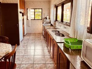 a kitchen with a sink and a counter top at Experiência única em Bombinhas frente ao Mar. in Bombinhas +3 photos