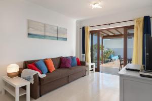 a living room with a brown couch with colorful pillows at Casa Lupa in Tías