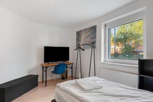 a bedroom with a bed and a desk and a window at Apartment Royal Blue by Maimark in Seckenheim