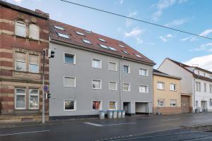 a gray building with a red roof on a street at Apartment Royal Blue by Maimark in Seckenheim