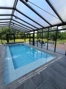 une grande piscine avec un grand toit dans l'établissement Gîte moderne à la campagne, à La Couture