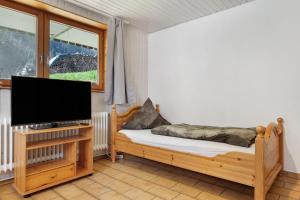 a bedroom with a bed and a flat screen tv at Hugenhof in Kirchzarten
