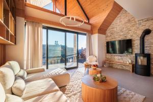 a living room with a couch and a tv at Stylchyn Park - Czorsztyn Exclusive - by Upstairs in Kluszkowce