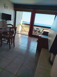 ein Wohnzimmer mit Tisch und Blick auf das Meer in der Unterkunft Appartement T2 Front de mer avec parking privatif - 4PC216 in Saint Cyprien Plage + 18 Fotos