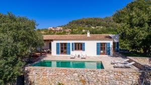 a villa with a swimming pool in front of a house at Finca Es Garballó in Son Servera