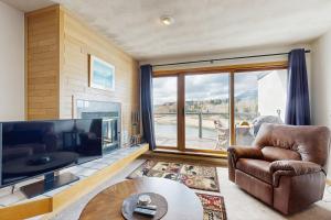 - un salon avec une grande télévision, un canapé et une table dans l'établissement East Bay 6, à Dillon