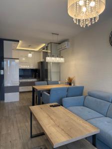 ein Wohnzimmer mit einem blauen Sofa und einem Tisch in der Unterkunft ApartamentywInie in Inowrocław