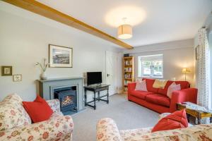 CharminsterにあるRuth'sのリビングルーム(赤いソファ、暖炉付)