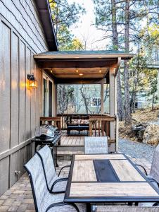 eine Terrasse mit einem Holztisch und Stühlen auf einem Haus in der Unterkunft Relax & Recharge in Cozy Pinetop 2BR Retreat in Pinetop-Lakeside + 14 Fotos