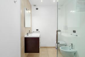 un bagno con lavandino, WC e specchio di Villa Marconi Apartment 9 a Golfo Aranci Altre 19 foto